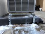 An image of a air source heat pump in the snow